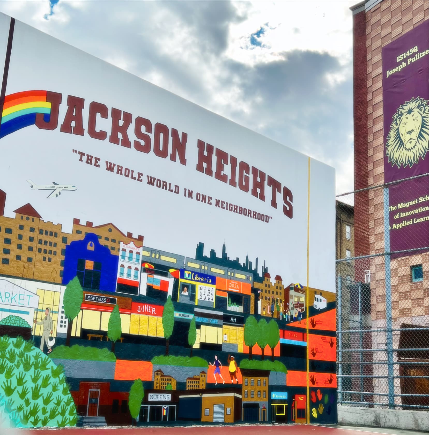 Jackson Heights mural showing 'THE WHOLE WORLD IN ONE NEIGHBORHOOD' with colorful cityscape